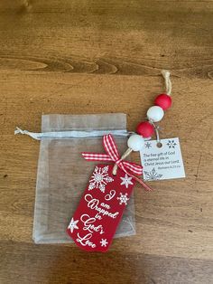 a red and white christmas stocking on top of a wooden table next to a bag