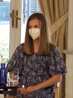 a woman wearing a face mask and holding a tray