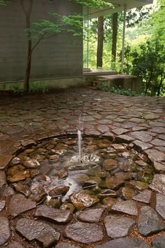 a water fountain in the middle of a stone patio