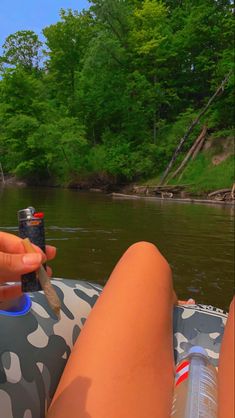 a person is sitting in an inflatable raft holding a lighter and looking at the camera