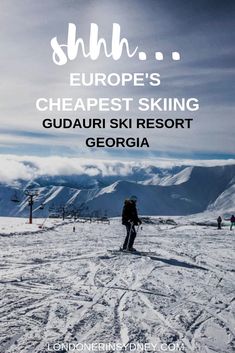 a person standing on top of a snow covered slope with skis in the background