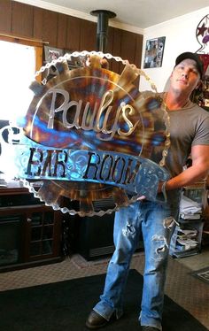 a man holding a sign that says paul's bar room in front of him