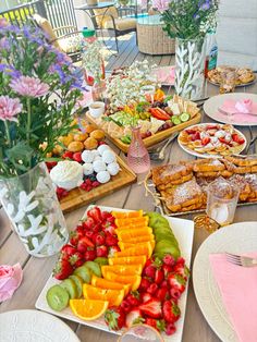 a table filled with lots of different types of food on plates and serving utensils