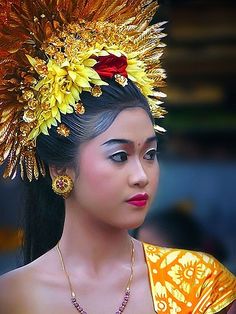 a woman wearing an elaborate head piece with flowers in her hair