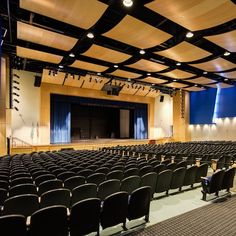 an empty auditorium filled with black chairs