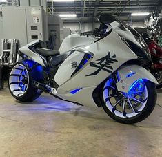 a white and blue motorcycle parked in a garage