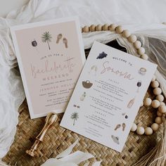 the wedding stationery is laid out on a wicker basket with beads and tassels