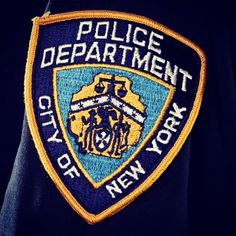 a police badge on the back of a man's black jacket that says city of new york