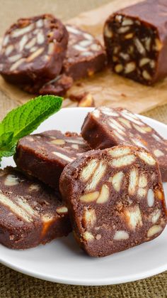 some brownies on a white plate with a green leaf