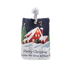 a christmas ornament hanging from a string on a white background with a red house in the snow