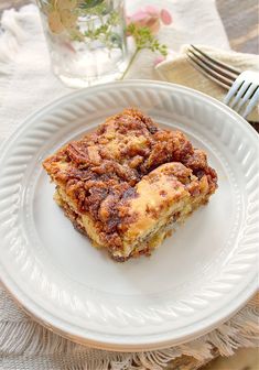 a white plate topped with two pieces of cake next to a fork and glass cup