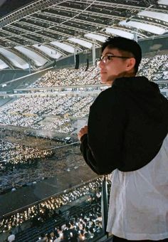 a man standing in front of a large stadium filled with people