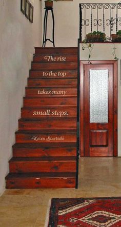 a stair case with a quote on the side and an area rug underneath it that says, to the rise to the top takes many small steps