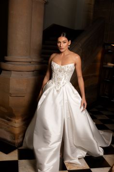 a woman in a white wedding dress standing next to some stairs