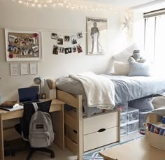 a dorm room with a bed, desk and laptop on the table in front of it