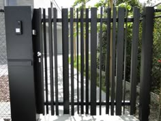 the gate is made of black metal and has vertical bars on each side that lead to an entrance