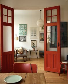 an open door leading into a living room filled with furniture and art on the walls