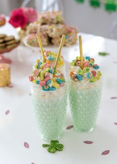 two cups filled with cake and sprinkles on top of a white table