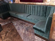 a green couch sitting on top of a wooden floor