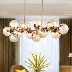 a modern chandelier hanging from the ceiling in a living room