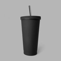 a black cup with a straw sticking out of it's lid on a gray background