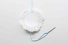 a white doily with a blue thread on it