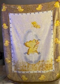 a baby's blanket with ducks on it is hanging from the side of a wall