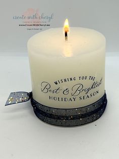 a candle with a ribbon around it that says wishing you the best and bright holiday season