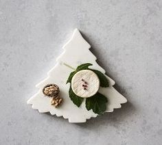 a white plate topped with an apple and walnuts on top of a gray surface