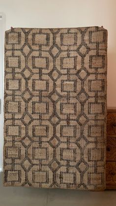 a brown and black area rug sitting on top of a wooden dresser next to a white door