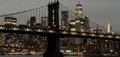 the city skyline is lit up at night as seen from across the water in new york