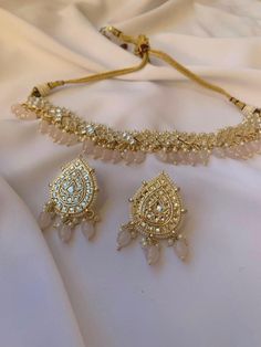 Introducing our exquisite Pear Shaped Gold Earrings + Choker Necklace Set, a mesmerizing blend of elegance and tradition. Each piece is adorned with vibrantly colored pearls, adding a pop of sophistication to your outfit. The intricate detailing of the Silver Kundan Jewelry Stones enhances the allure, reflecting the rich heritage of Indian, Pakistani, and Desi jewelry. Available in both dark blue and lavender colored pearls, this set offers versatility and grace, making it the perfect choice for any occasion. Elevate your style with this timeless masterpiece, crafted to perfection for the modern woman who cherishes tradition with a contemporary twist. Pink Bridal Necklace With Matching Earrings As A Gift, Dark Blue And Lavender, Modern Wedding Jewelry, Desi Jewellery, Desi Jewelry, Colored Pearls, Neck Pieces Jewelry, Wedding Necklace Set, Jewelry Stones