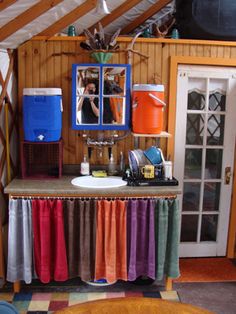 a room with a sink, mirror and other items on the table in front of it