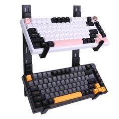 a computer keyboard and mouse stand with two keyboards attached to each other on a white background