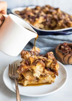 someone is pouring syrup on a piece of bread pudding