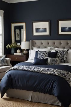 a bedroom with dark blue walls and white bedding in the center, along with two framed pictures on the wall