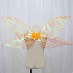 a white mannequin headdress with yellow wings