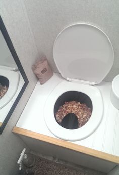 a white toilet sitting in a bathroom next to a sink with a mirror above it