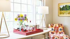 a living room filled with furniture next to a window and a painting on the wall