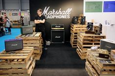 a man standing in front of stacks of wooden crates