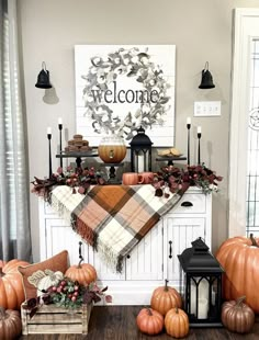 a fireplace decorated for fall with pumpkins and other decorations