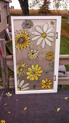 a painted glass door with yellow and white flowers on it