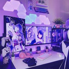 two computer monitors sitting on top of a desk in front of a purple wall with anime characters