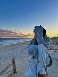 a person sitting on a bench at the beach