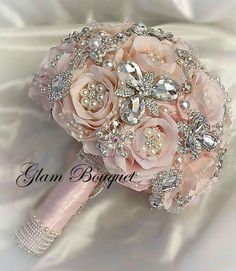 the bridal bouquet is made up of pink flowers and crystal stones, along with pearls