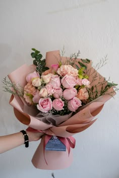 a person holding a bouquet of pink roses