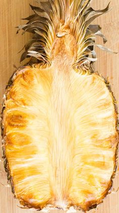 a pineapple cut in half sitting on top of a wooden table