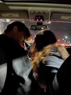 two people sitting in the back seat of a car