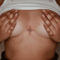 a woman's breast with a small star tattoo on her left side ribcage