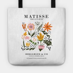 a white tote bag with an image of flowers and leaves on the front, in black